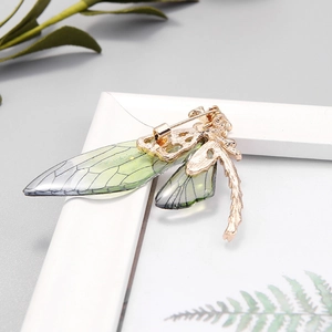 Exquisite golden dragonfly brooch with translucent green wings and shimmering accents