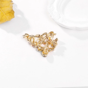Vue arrière d'une broche sapin de Noël dorée avec épingle de sûreté et détail d'étoile