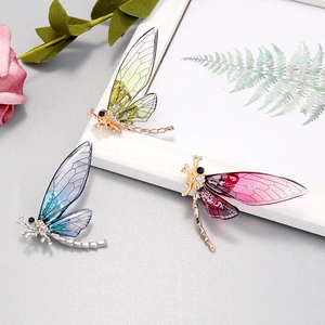 Colorful dragonfly brooches with rhinestones and translucent wings on display