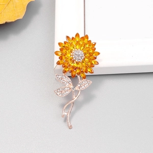 Broche tournesol exquise avec cristaux jaunes et or rose sur un fond gris élégant
