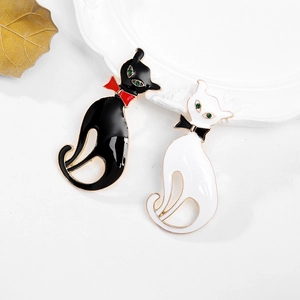 Détail de mignonnes broches chat en émail avec des yeux en strass vert brillant