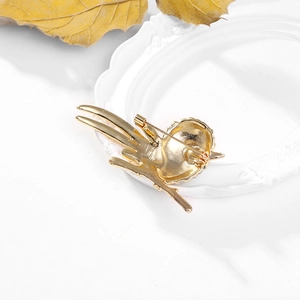 Broche chouette dorée avec mécanisme d'épingle au dos sur un cadre blanc élégant