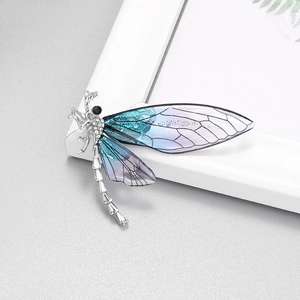 Detail of dragonfly brooch with crystal-studded body and blue-purple gradient wings