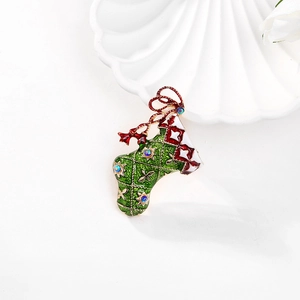 Exquisite Christmas stocking brooch with green enamel and red bow on white plate