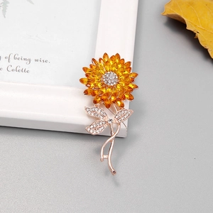 Vue détaillée d'une broche tournesol avec pierres jaunes et strass sur un cadre blanc