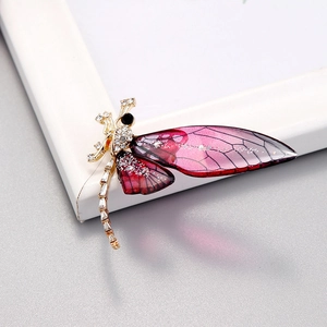 Detail of dragonfly brooch featuring purple gradient wings and sparkling diamond accents