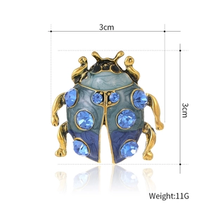 Colorful ladybug beetle brooch in blue and gold with dimensions of 3cm by 3cm