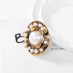 Macro shot of baroque pearl brooch with gold base, crystal accents and elegant textures