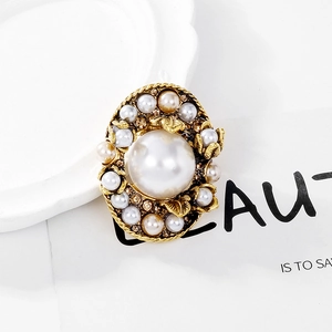 Macro shot of vintage baroque pearl brooch with champagne crystals and golden leaves