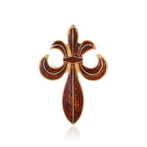 Macro detail of vintage fleur-de-lis brooch with amber enamel and gold finish