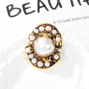 Baroque vintage pearl brooch with gold leaf design and rhinestones on white frame