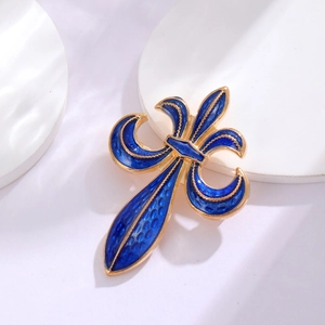 Detail of vintage fleur-de-lis brooch with blue enamel and golden metal texture