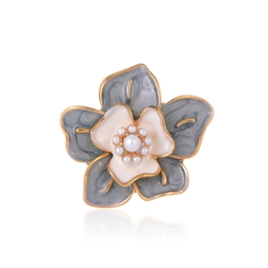 Detail of camellia brooch with grey enamel petals, golden edges and white pearls