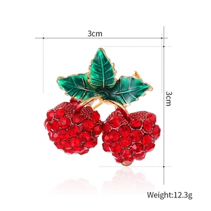 Broche cerise scintillante avec strass rouges et feuilles en émail vert sur base dorée