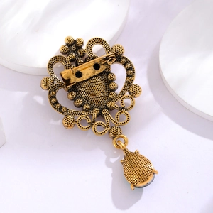 Vintage gold baroque heart brooch with rhinestone waterdrop pendant on white background