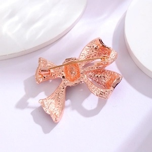 Rose gold bow brooch with pin closure featuring textured surface and elegant butterfly design