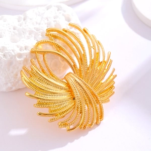 Détail d'une broche fleur dorée en éventail avec texture torsadée élégante et finition polie