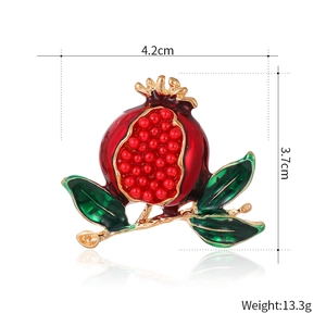 Fashionable pomegranate brooch with red enamel seeds and gold branches on white background