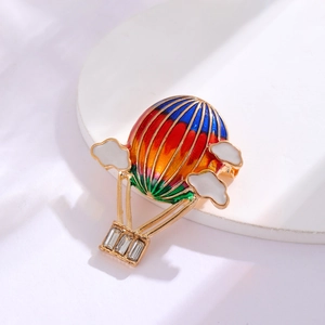 Macro view of a colorful rainbow enamel hot air balloon brooch with sparkling zircons