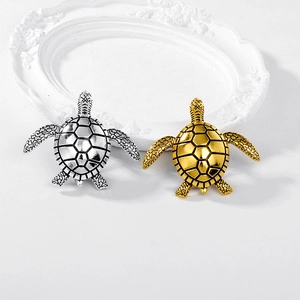 Set of minimalist turtle brooches in gold and silver finish with geometric shell patterns