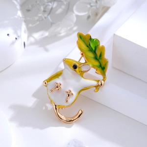Close-up of cute cartoon mouse brooch with green leaf and colorful enamel finish