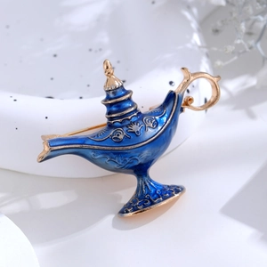 Macro detail of Aladdin magic lamp brooch with blue enamel and vintage gold metal patterns