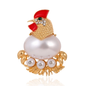 Vintage gold rooster brooch with white pearl body and red enamel comb on white background
