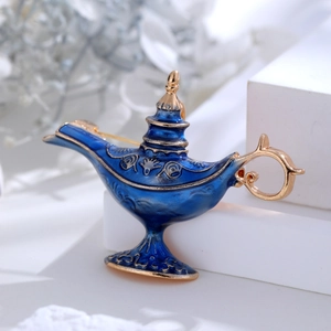 Macro detail of exotic Aladdin lamp brooch with blue enamel and gold floral engraving