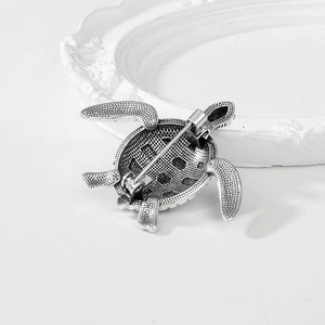 Vintage silver turtle brooch showing the detailed back structure and safety pin clasp