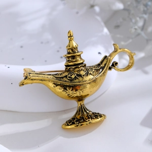Detailed close-up of vintage magic lamp brooch with antique gold floral relief patterns