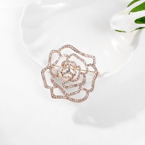 Vue macro d'une élégante broche rose avec strass étincelants sur métal doré ajouré