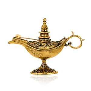 Macro view of vintage gold Aladdin lamp brooch with intricate embossed patterns and details