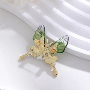 Elegant gold-plated butterfly brooch with translucent green wings and safety pin back