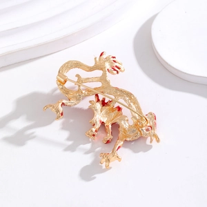 Broche dragon doré avec détails en émail rouge et épingle de sûreté sur plateau