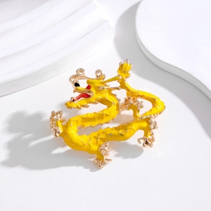 Détail d'une broche dragon dorée avec émail jaune et finitions métalliques précises