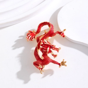 Broche dragon rouge et or exquise avec écailles en émail sur un socle de présentation blanc