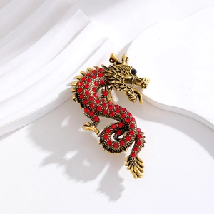 Retro golden Chinese dragon brooch with red rhinestones on a minimalist white stage