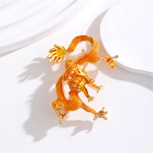 Vue détaillée de la broche dragon doré avec écailles en émail orange brillant