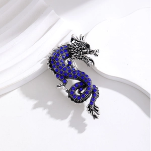 Detailed view of dragon brooch with deep blue rhinestones on a minimalist background