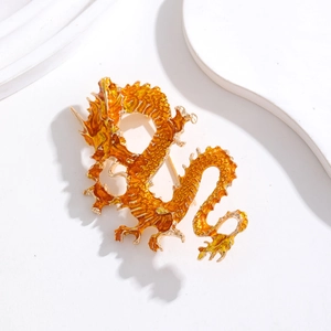 Vue macro d'une broche dragon en émail doré sur fond blanc artistique