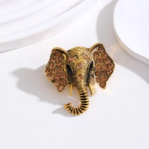 Detail van vintage gouden olifant broche met amber strassteentjes en zwart edelsteenoog