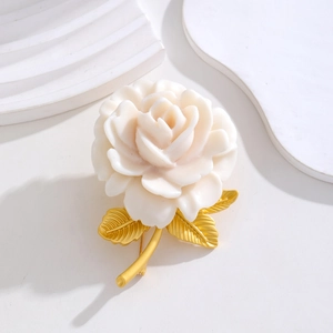 Close-up of vintage cream rose brooch with matte gold leaves and detailed texture