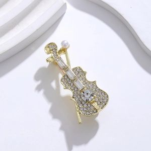 Broche violon élégante sertie de strass et perle blanche sur un support minimaliste blanc