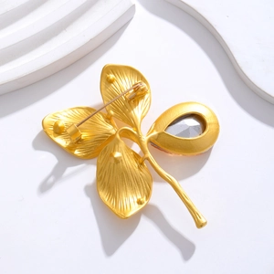 Vintage gold clover brooch with s925 stamp and drop-shaped crystal on white background