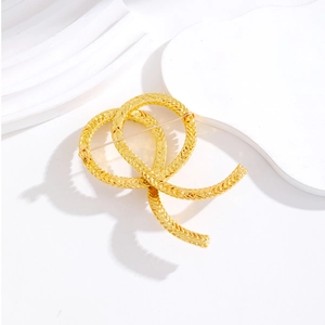 Vintage style gold twisted rope brooch with interlaced ring design for coats and suits