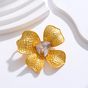 Vintage matte gold flower brooch with hammered metal texture and amber crystal center