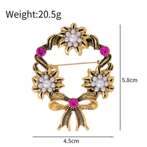 Vintage gold wreath brooch with white pearl petals and magenta rhinestones for elegant styling