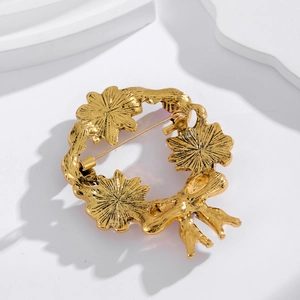 Back view of a gold floral wreath brooch with ribbon bow and secure metal pin closure
