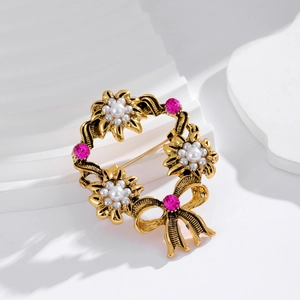 Vintage gold wreath brooch with pink rhinestones, faux pearls and a bow decoration