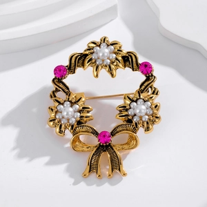 Detail showing vintage gold wreath brooch with white pearls and pink crystals